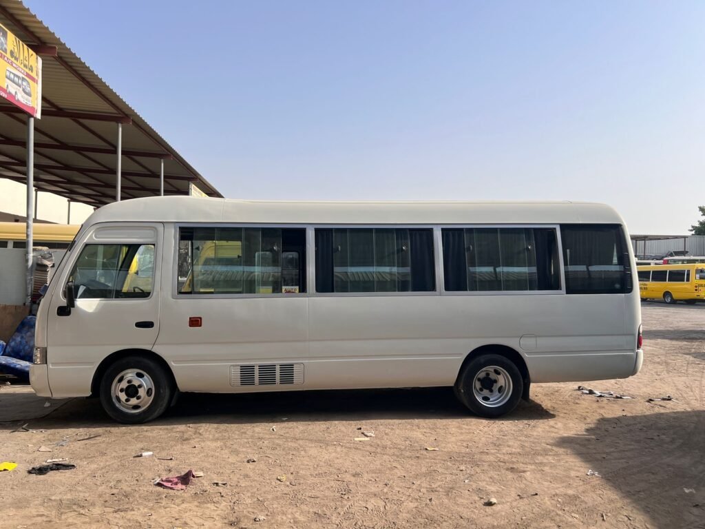 A 26-seater bus and 22-seater Toyota Coaster bus available for rent in Dubai, ideal for group travel with ample seating options.