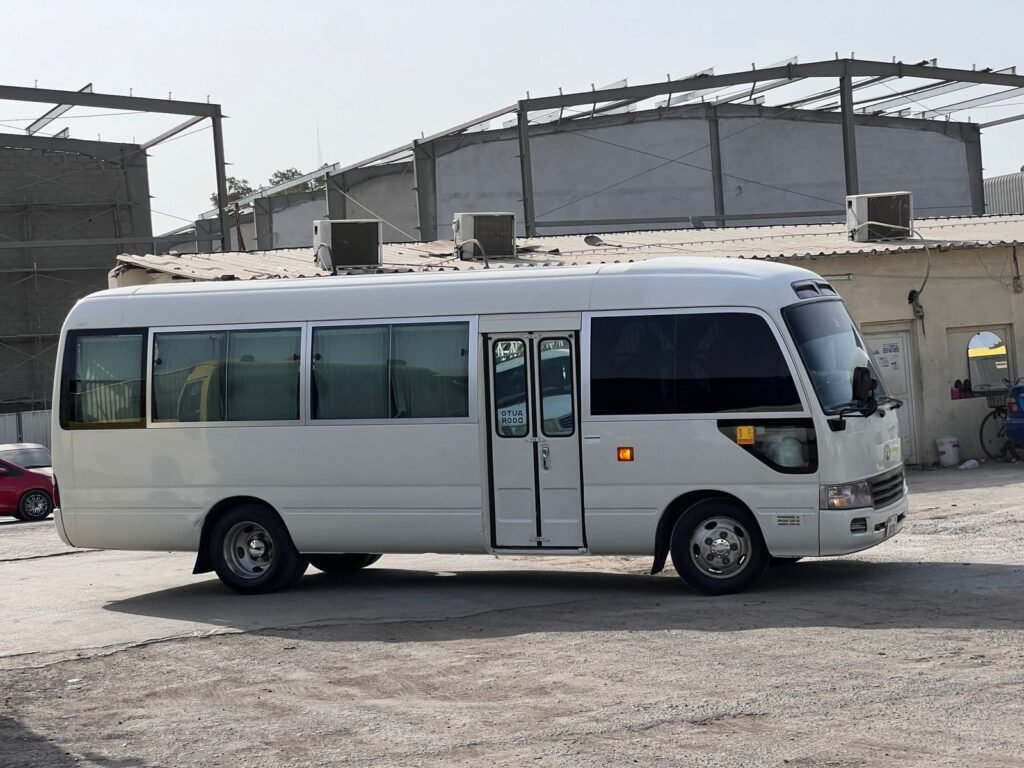 A 30-seats Toyota Coaster bus available for rent in Dubai, providing ample space and comfort for group travel.